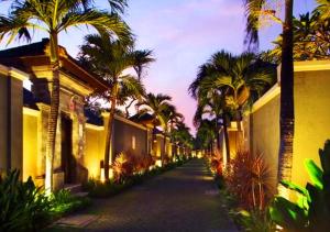 une rue vide avec des palmiers et des bâtiments dans l'établissement The Ulin Villas and Spa - by Karaniya Experience - CHSE certified, à Seminyak