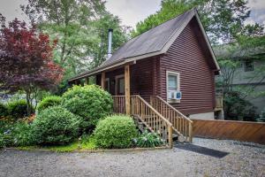 Casa pequeña con porche y escalera de madera en Mountainaire Inn and Log Cabins, en Blowing Rock