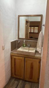y baño con lavabo y espejo. en Cabañas Yasmina, en Mazamitla