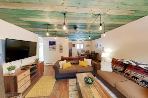 a living room with a couch and a flat screen tv at Mountain Escape in Taos Ski Valley