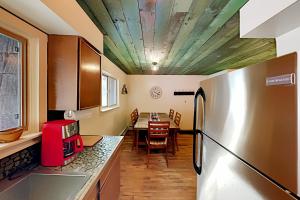 a kitchen with a refrigerator and a table with chairs at Mountain Escape in Taos Ski Valley