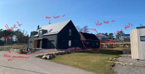 a black house with red writing on the side of it at Friluftsstigen Cabin in Falkenberg