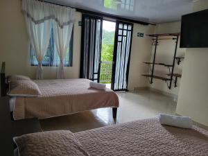 a bedroom with two beds and a balcony with windows at Alojamiento Rural Casa de Campo Erika Sofia in Rivera +135 photos