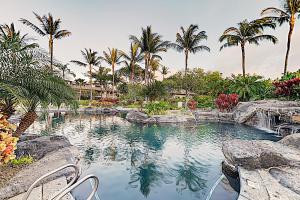 una piscina con palmeras en un resort en Mauna Lani Villa A-22, en Waikoloa