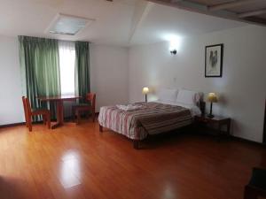 1 dormitorio con cama, mesa y ventana en Room in Guest room - Amazing Junior Suite Close The Airport And Trade Center, en Bogotá