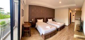 a bedroom with two beds and a balcony at J.P.GRAND HOTEL in Trat