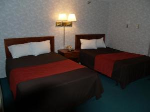 a hotel room with two beds and two lamps at Bangor Inn & Suites in Bangor