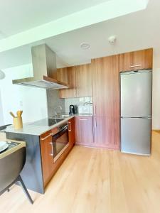 a kitchen with wooden cabinets and a stainless steel refrigerator at Apartamento Valle de Alba in Benasque