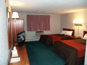 a hotel room with two beds and a television at Bangor Inn & Suites in Bangor
