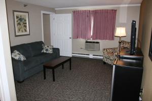 un soggiorno con divano e tavolo di Bangor Inn & Suites a Bangor