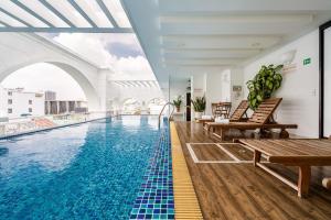 a swimming pool with chairs and a table in a building at SaiGon Huch Villa in Ho Chi Minh City