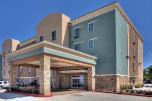 ein großes Gebäude mit Parkplatz in der Unterkunft Comfort Inn & Suites, White Settlement-Fort Worth West, TX in Fort Worth