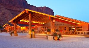 a restaurant with a building with a mountain in the background at Red Cliffs Lodge in Moab