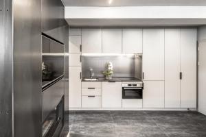 a kitchen with white cabinets and a stove at Loft on 1236 in Ortisei