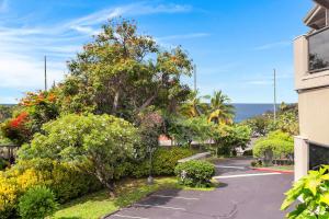 a parking lot with trees and bushes next to the ocean at Casa Tropical Kona in Kailua-Kona