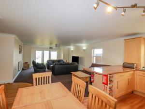 a kitchen and living room with a couch and a table at 1 Spinnakers in Newquay