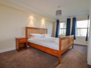 - une chambre avec un grand lit et une tête de lit en bois dans l'établissement 1 Spinnakers, à Newquay