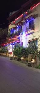 a building with blue and purple lights on a street at Al Midan Hotel in Amman