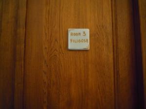 een bord op een houten deur die kamer leest bij Casa Castori in Macomer