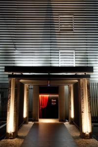 un edificio con un túnel con una cortina roja en Think・Hotel・Think, en Ebina