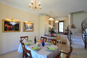 a dining room with a table and a kitchen at Le Petit Palais Villa in Plesio