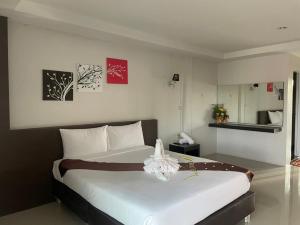 a bedroom with a large white bed in a room at โกอิ้งแกรนด์ in Ban Hua Trut