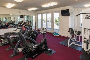 una sala de fitness con cintas de correr y máquinas elípticas en The Sandbridge Dunes - Serenity 206, en Virginia Beach