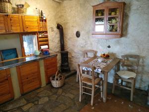 kuchnia ze stołem, krzesłami i kuchenką w obiekcie Wellanidia Cottage Skoutari w mieście Gythio +33 zdjęcia
