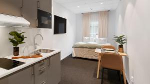 a kitchen with a sink and a bed in a room at Stockholm Hotel Apartments Arlanda XPO in Arlanda