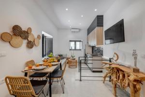 a kitchen and living room with a table and chairs at SyRose Suites in Ermoupoli