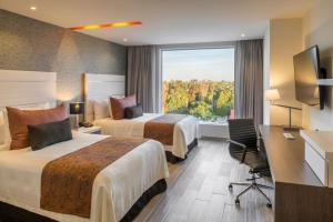 a hotel room with two beds and a window at Real Inn Celaya in Celaya