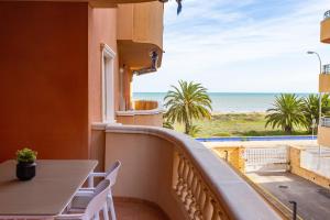 een balkon met een tafel en uitzicht op de oceaan bij Dénia FRONT BEACH Apartment in Denia