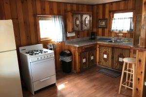 a kitchen with a stove and a refrigerator at Elkhorn Lodge in Chama