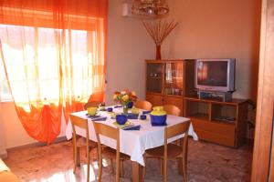 sala de estar con mesa y TV en Bed and Breakfast Luna Chiara, en Piazza Armerina