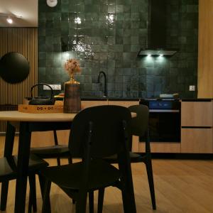 eine Küche mit einem Tisch mit 2 Stühlen und einem Waschbecken in der Unterkunft Apartamenty Białystok - Apartment Royal VI in Białystok