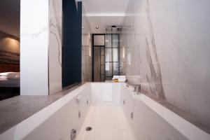 a white bath tub in a bathroom with a sink at Berjer Boutique Hotel & Spa in Istanbul