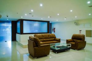 a living room with two couches and a glass table at Welkin Hotel in Secunderabad