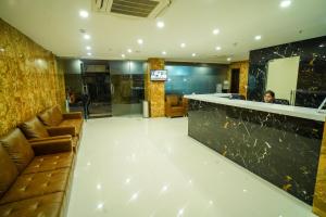 a woman sitting at a bar in a hotel lobby at Welkin Hotel in Secunderabad