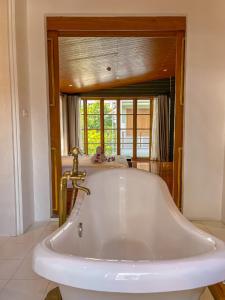 a white bath tub in a bathroom with a window at Vali Villa Bangkok in Bangkok