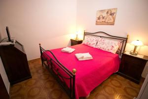 タオルミーナにあるCasa Rosyのベッドルーム1室(赤いベッド1台、タオル2枚付)