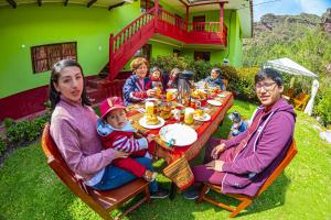 a group of people sitting at a table in the yard at Happy Land Valle Sagrado in Urubamba