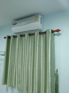 a room with a shower curtain and a air conditioner at OYO 75400 Moo Yim Resort in Rayong