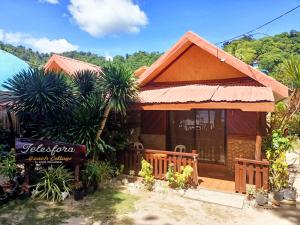 a house with a sign in front of it at Telesfora Beach Cottage in El Nido