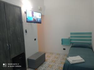 1 dormitorio con 1 cama y TV en la pared en Casa Vacanze Central Cincotta, en Lipari