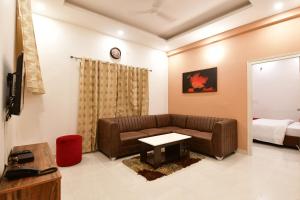 uma sala de estar com um sofá e uma cama em Xcel Luxury Hotel Apartments-Home Living Redefined em Mysore