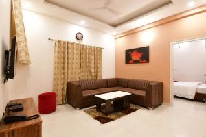 a living room with a couch and a bed at Xcel Luxury Hotel Apartments-Home Living Redefined in Mysore