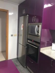 a kitchen with a refrigerator and a microwave at CASA NOUR con parking in Elche
