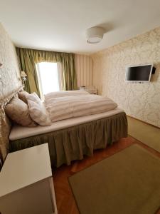 a hotel room with a bed and a television at Villa Sukka in Winterlingen