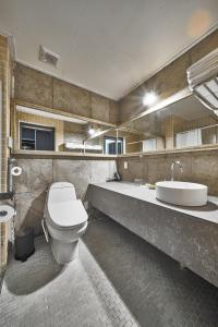 a bathroom with a toilet and a sink and a tub at Lareem Boutique Hotel in Seogwipo