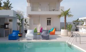 a swimming pool with chairs and a house at Villa Stergos in Kremasti
